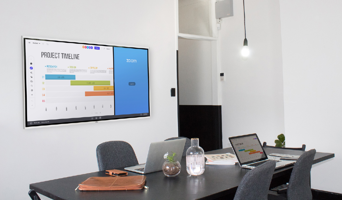 A conference room featuring an interactive whiteboard sits empty before the virtual meeting begins.