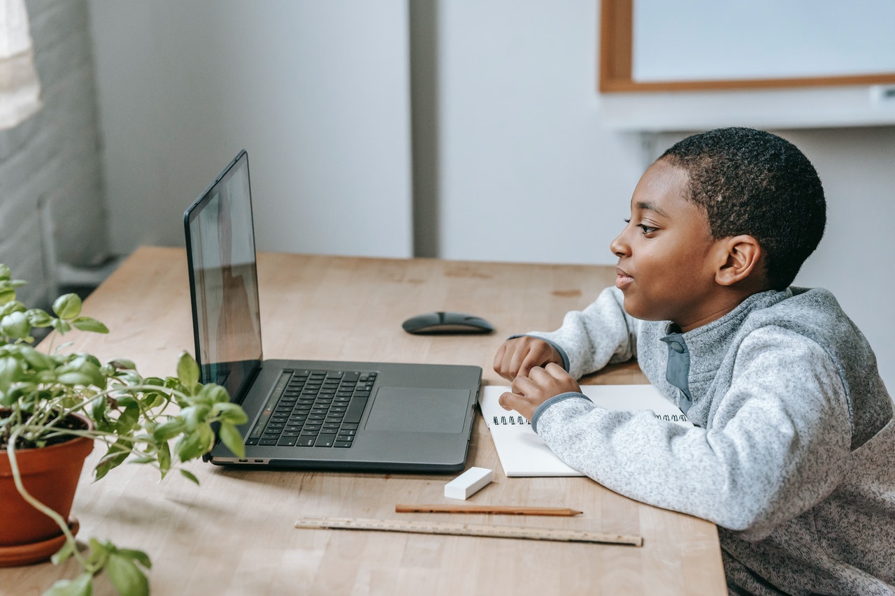 A young boy watches an online math lesson as part of his distance learning curriculum.